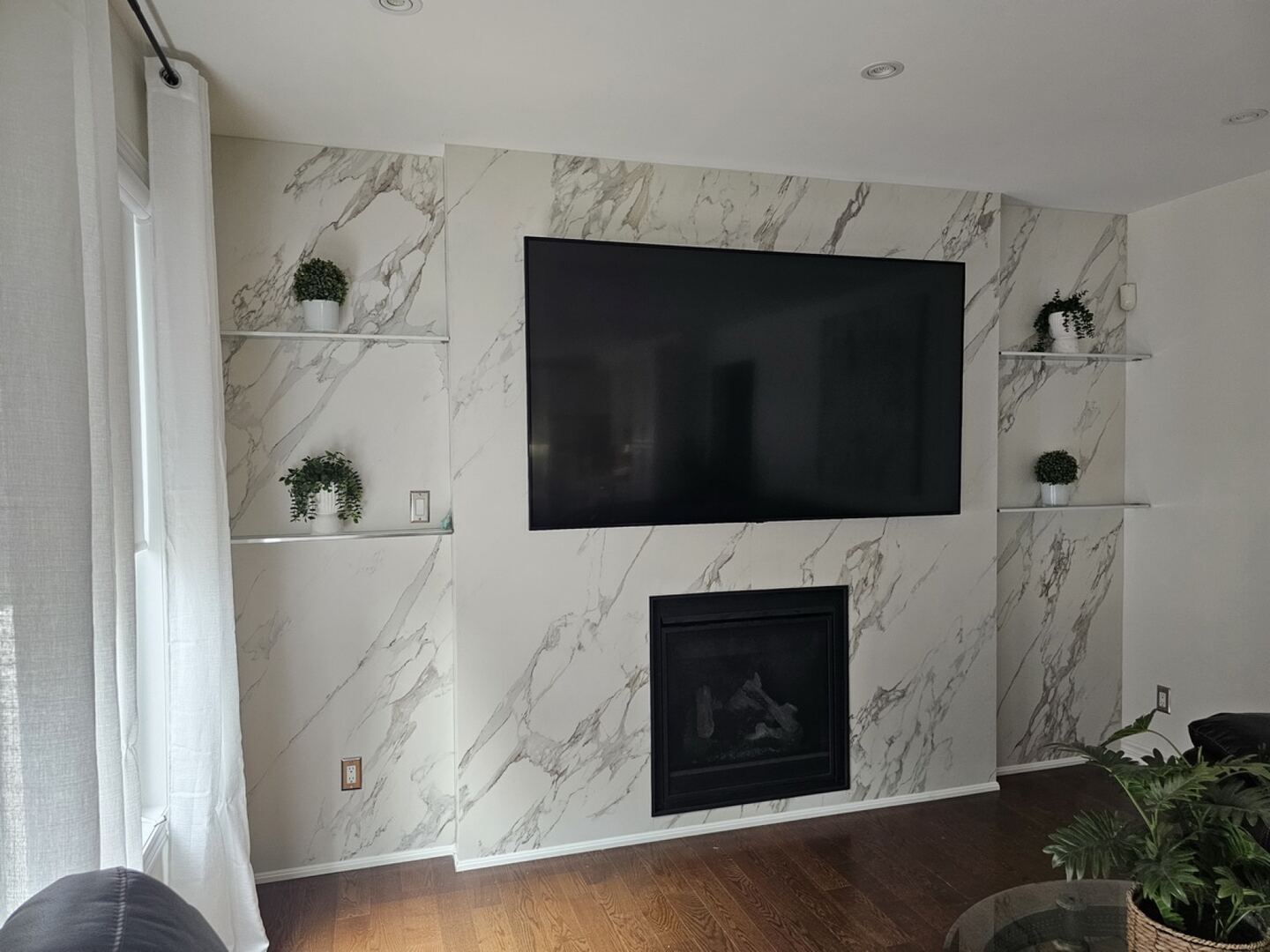 Bookmatched natural stone fireplace feature installed by Pearl Countertops